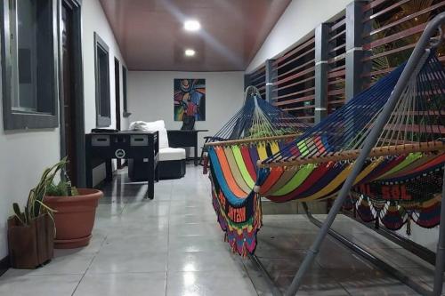 a hammock in a living room with a piano at Casa Tierra Viva in Managua