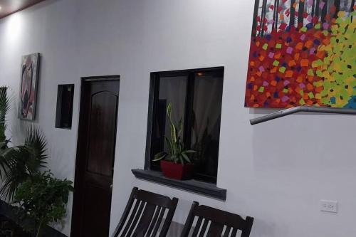 a dining room with chairs and a painting on the wall at Casa Tierra Viva in Managua