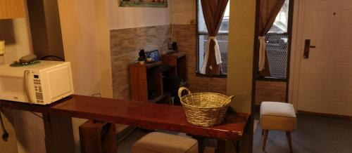 a kitchen with a microwave and a table with a basket at La Juana in Carmelo