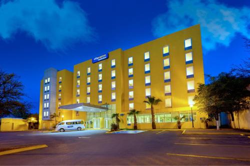 a yellow building with a van parked in front of it at City Express by Marriott Saltillo Sur in Saltillo