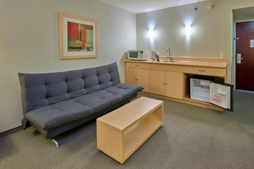 a living room with a couch and a kitchen at City Express by Marriott Saltillo Sur in Saltillo