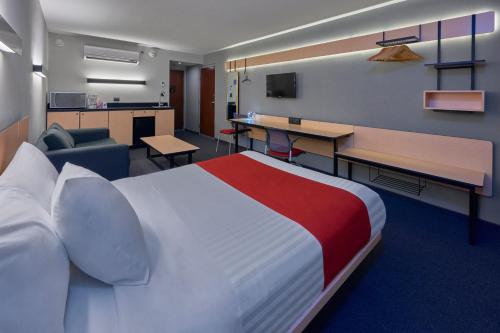 a hotel room with a large bed and a desk at City Express by Marriott Irapuato Norte in Irapuato