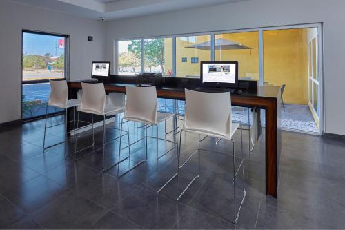a conference room with a long table with white chairs at City Express by Marriott Irapuato Norte in Irapuato