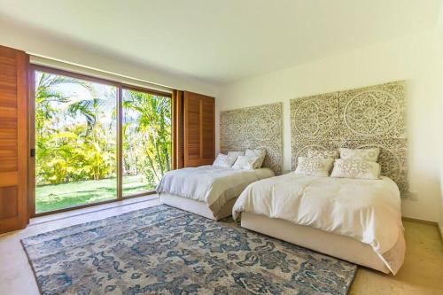 ein Schlafzimmer mit zwei Betten und einem großen Fenster in der Unterkunft Luxury Modern Punta Mita Condo 3 bdrm, sleeps 8 with Golf access in Punta Mita