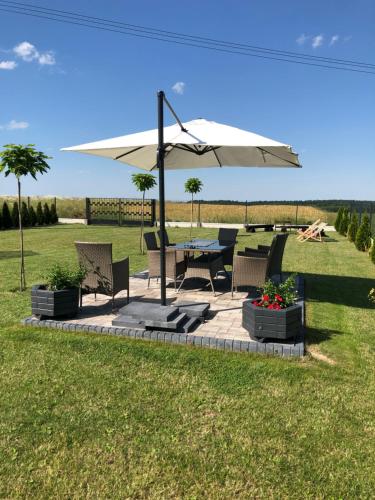 une terrasse avec une table et un parasol dans l'établissement Noclegi DobraNocka, à Sąpów