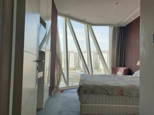 um quarto de hotel com uma cama e uma grande janela em luxuary apartment in a 5-star hotel em Istambul