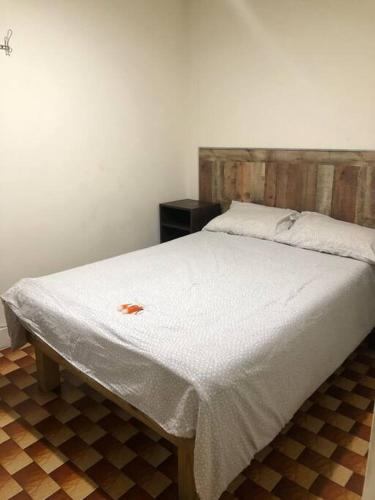 uma cama com uma colcha branca e uma cabeceira em madeira em 1C CLOSe em Nova York