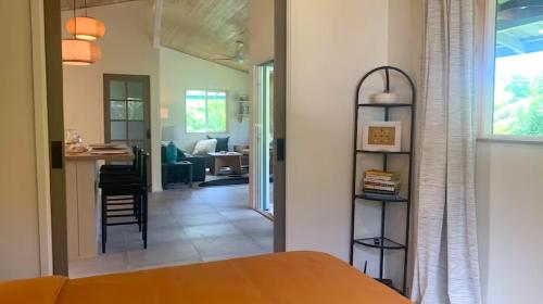 a bedroom with a bed and a living room at Seaside House and Aloha Bungalow in Pahoa