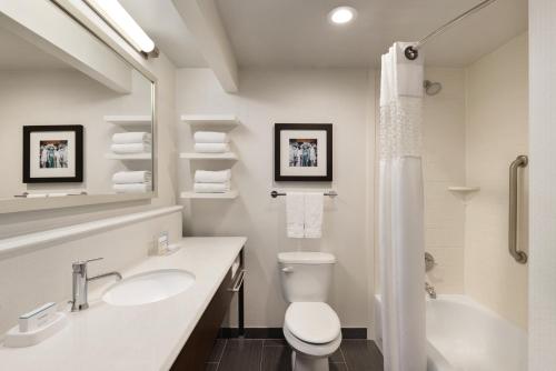 a bathroom with a toilet and a sink and a tub at Hampton Inn and Suites New Orleans Convention Center in New Orleans