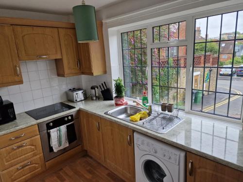 a kitchen with a sink and a washing machine at Millmead Apartment in central Guildford with parking in Guildford