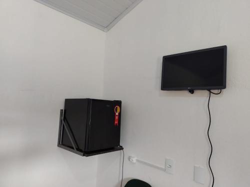 a flat screen tv hanging on a wall at Chalés relíquia canastra in São Roque de Minas