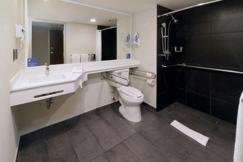 y baño con aseo, lavabo y ducha. en City Express by Marriott Piedras Negras, en Piedras Negras