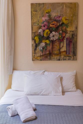 a bedroom with a bed with a painting on the wall at Meztli: Casa Boutique & Spa in Mexico City