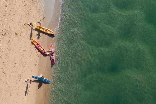 two boats on a beach next to the water at Jacaranda Villa Korora Beach NSW in Kororo Basin