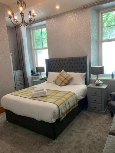 a bedroom with a large bed with two tables and two lamps at Chandlers Country House in Rothesay