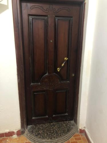a wooden door in a room with a brick floor at Zagazig in Manshīyat as Sādāt