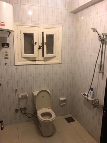 a bathroom with a toilet and two windows in it at Zagazig in Manshīyat as Sādāt