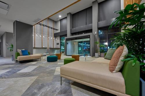 un vestíbulo con sofás y plantas en un edificio en City Express Plus by Marriott Tampico, en Tampico