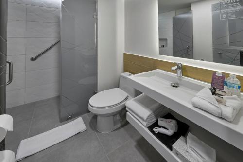 een badkamer met een toilet, een wastafel en een douche bij City Express Plus by Marriott Tampico in Tampico