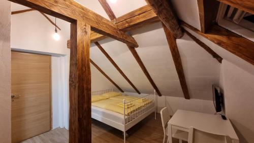 Dormitorio pequeño en el ático con cama y mesa en Apartments Žnidar, en Bohinj