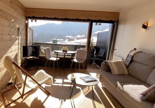 a living room with a couch and a table at Studio lumineux avec vue sur le Mont Blanc in Cordon
