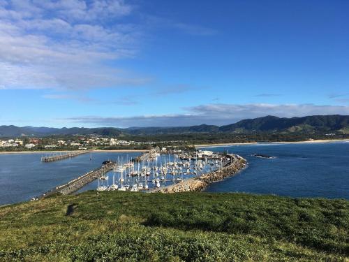 a bunch of boats docked at a dock in the water at Jacaranda Villa Korora Beach NSW in Kororo Basin