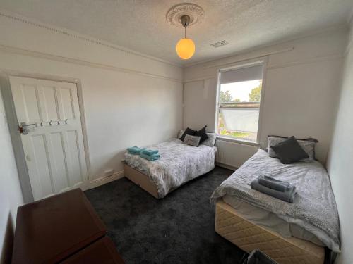 a bedroom with two beds and a window at Spacious 3bed house in Southend-on-Sea
