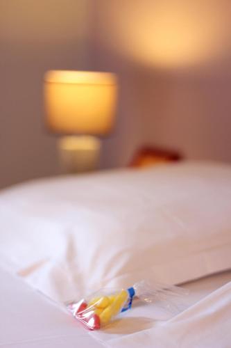 a toothbrush sitting on top of a bed at Ô Villagio Hôtel in Villeneuve-Loubet