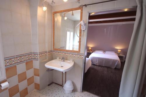 a bathroom with a sink and a bed at Ô Villagio Hôtel in Villeneuve-Loubet
