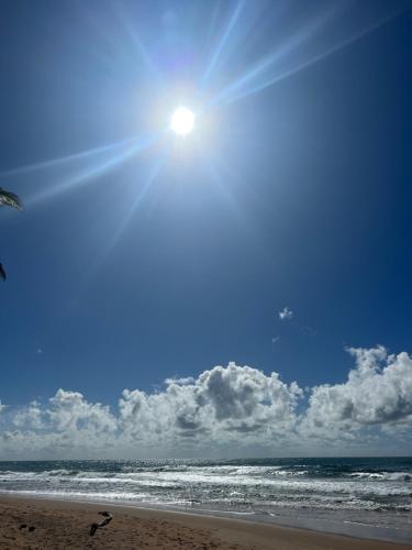 a beach with the sun in the sky and the ocean at Pousada Oceano Atlântico in Marau