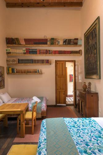 a room with two beds and a table and a desk at Meztli: Casa Boutique & Spa in Mexico City