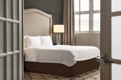 a bedroom with a bed with a headboard and a window at Hampton Inn and Suites New Orleans Convention Center in New Orleans