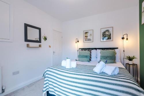 a bedroom with a large bed with a striped blanket at Spacious 3-bed home in Nantwich by 53 Degrees Property - Amazing location, Ideal for Groups - Sleeps 6 in Nantwich