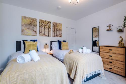 a bedroom with two beds and a dresser at Spacious 3-bed home in Nantwich by 53 Degrees Property - Amazing location, Ideal for Groups - Sleeps 6 in Nantwich