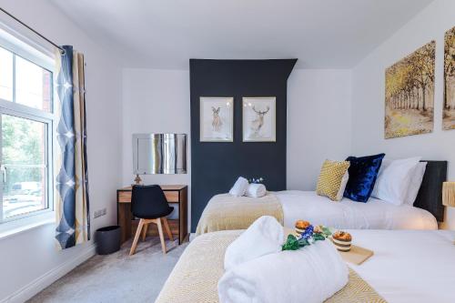 a bedroom with two beds and a desk and a window at Spacious 3-bed home in Nantwich by 53 Degrees Property - Amazing location, Ideal for Groups - Sleeps 6 in Nantwich