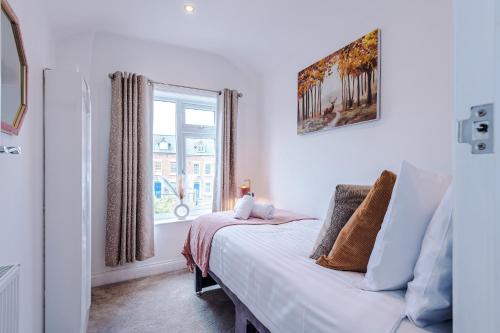 a white bedroom with a bed and a window at Spacious 3-bed home in Nantwich by 53 Degrees Property - Amazing location, Ideal for Groups - Sleeps 6 in Nantwich