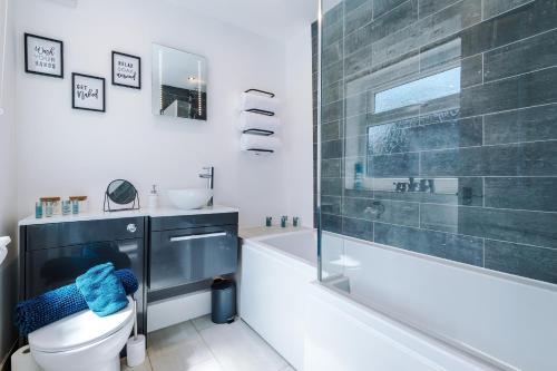 uma casa de banho com uma banheira, um WC e um lavatório. em Spacious 3-bed home in Nantwich by 53 Degrees Property - Amazing location, Ideal for Groups - Sleeps 6 em Nantwich