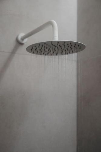 a shower with a shower head and a hose at Iasmos Luxury Apartment in Heraklio Town
