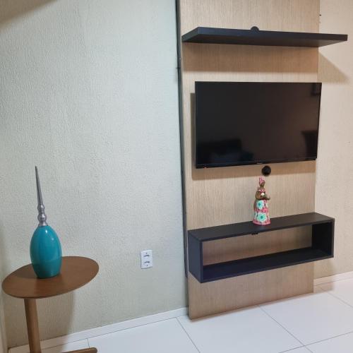 a living room with a tv and a table at Apartamento Dei Fiori in Guaramiranga