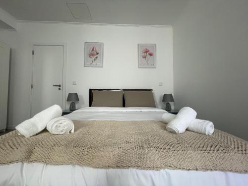 1 dormitorio con 1 cama grande con sábanas y almohadas blancas en Charming Benavente, en Benavente