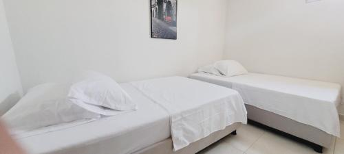 2 camas blancas en una habitación con una foto en la pared en Lujoso LOFT en el Centro, en Cartago