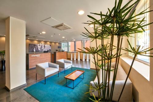 a lobby with chairs and a table and a plant at City Express by Marriott Queretaro Autopista in Querétaro