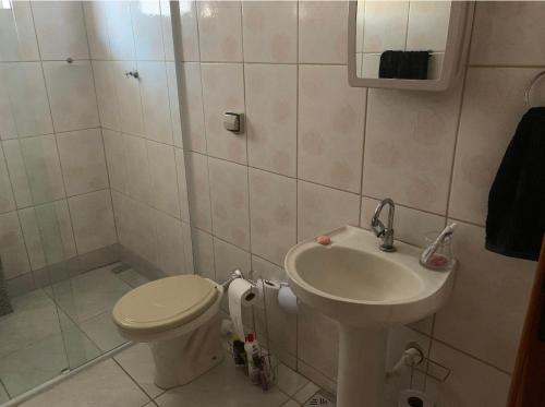 un baño con inodoro y lavabo en Apartamento confortável com espaço exclusivo, en Cachoeira Paulista