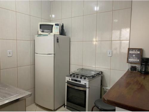 una pequeña cocina con microondas encima de una nevera en Apartamento confortável com espaço exclusivo, en Cachoeira Paulista