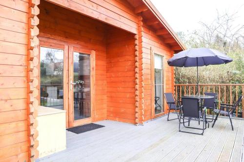 a wooden deck with a table and an umbrella at Unique 1 bed Flat Near Heathrow in Hillingdon