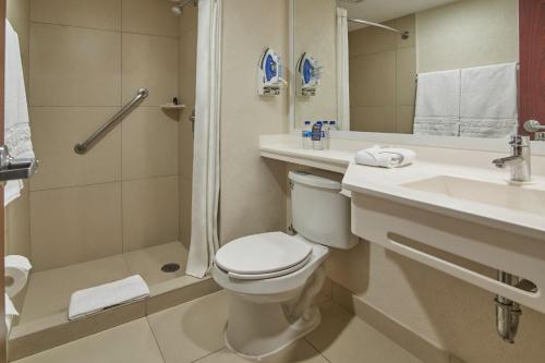 Un baño con inodoro, lavabo y ducha. en City Express by Marriott Puebla FINSA, en Puebla