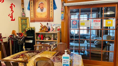 a dining room with a table and chairs and a window at miniモンゴルキャンプ場 in Gujo