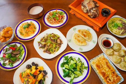 a wooden table with plates of food on it at miniモンゴルキャンプ場 in Gujo
