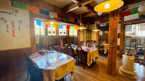 un ristorante con tavoli, sedie e vetrate istoriate di miniモンゴルキャンプ場 a Gujo