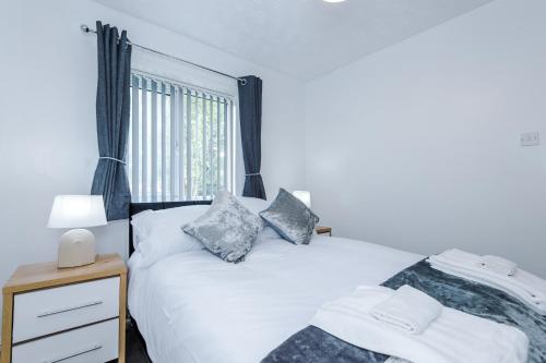 曼徹斯特的住宿－Cozy Home Away From Home in Manchester.，一间卧室设有两张床和窗户。